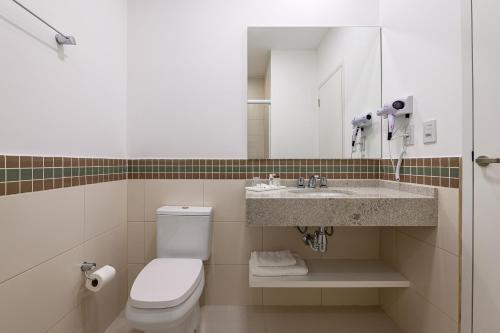 a bathroom with a toilet and a sink at Hotel Maerkli in Santo Ângelo