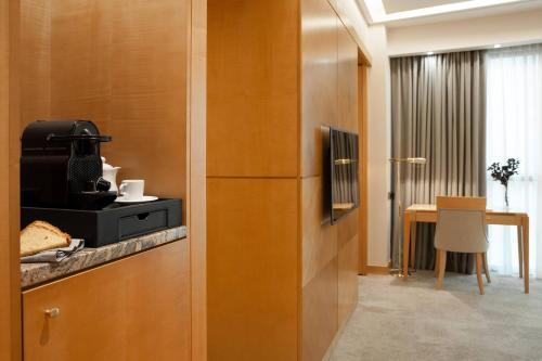 a room with a refrigerator and a table with a chair at Meliá Athens in Athens