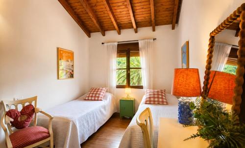 a bedroom with two beds and a table and chairs at Villa Costa Cue in Cue