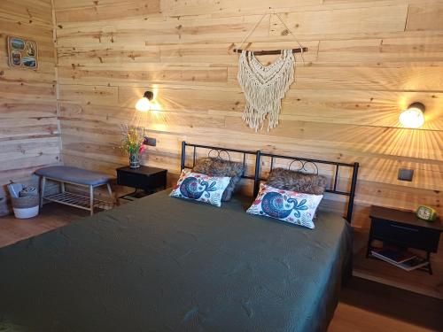 a bedroom with a bed with a wooden wall at Lugar dos Meandros 