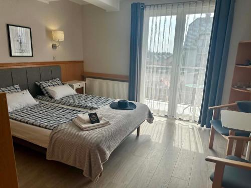 a bedroom with a bed and a large window at Pensjonat Nautilus in Karwia