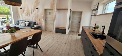 a kitchen and living room with a table and a couch at Gartenbungalow Rhönwald in Hilders