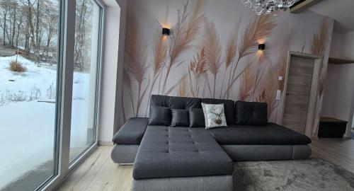 a living room with a couch and a large window at Gartenbungalow Rhönwald in Hilders