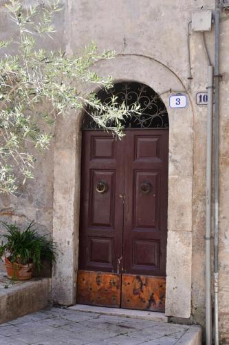a large wooden door in a building with an arch at Gran Paradiso Guest House in Tivoli