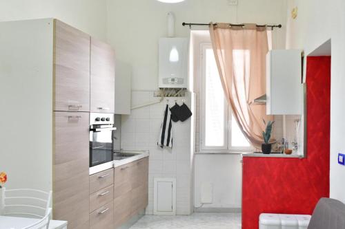 a kitchen with white cabinets and a red refrigerator at Gran Paradiso Guest House in Tivoli