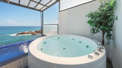a bath tub in a bathroom with a view of the ocean at yeongdeok chaeumneul poolvilla in Yŏngdŏk