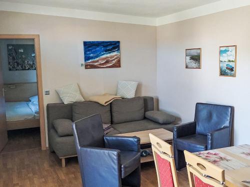 a living room with a couch and a table and chairs at Holiday Home Goetheallee by Interhome in Krakow am See