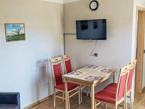 a dining room table with chairs and a clock on the wall at Holiday Home Goetheallee by Interhome in Krakow am See