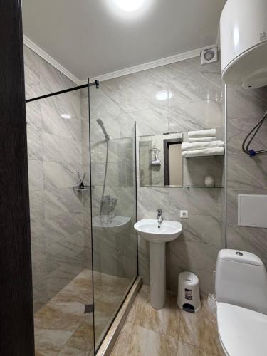 un bagno con doccia, lavandino e WC di Hotel Sofiyvka Park a Umanʼ