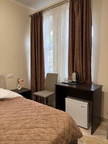 una camera da letto con un letto, una scrivania e una finestra di Hotel Sofiyvka Park a Umanʼ