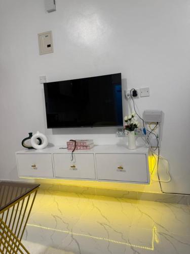 a white dresser with a tv on top of it at Coastal comfort studio apartment in Mombasa