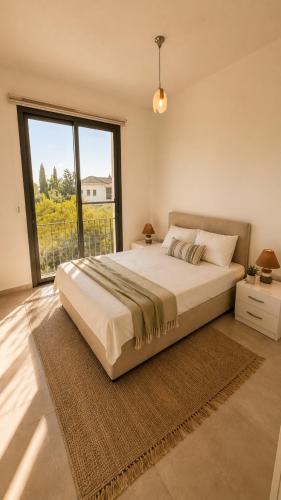 a bedroom with a large bed and a large window at Kıbrıs Town House Menekşe in Aglantzia