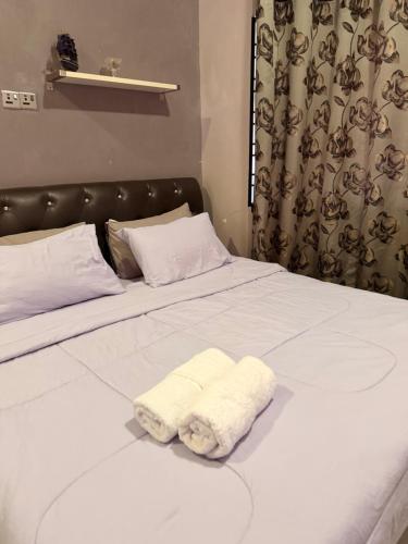 a bed with a white towel on it at Homestay Permai Inn in Temerloh