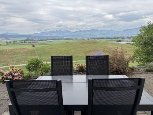 a table and chairs with a view of a field at Apartment Luxenweid by Interhome in Reichenburg