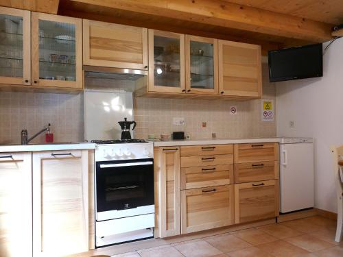 a kitchen with wooden cabinets and a white stove top oven at Holiday Home Rustico Nurell by Interhome in Madra