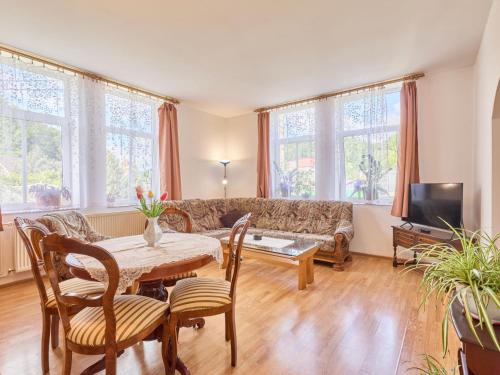 a living room with a table and a couch at Apartment Riedlovka 2 by Interhome in Polubný