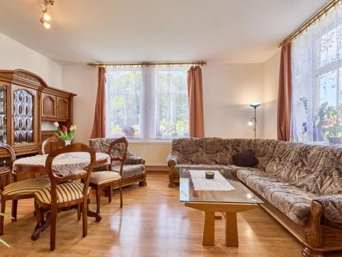 a living room with a couch and a table at Apartment Riedlovka 2 by Interhome in Polubný