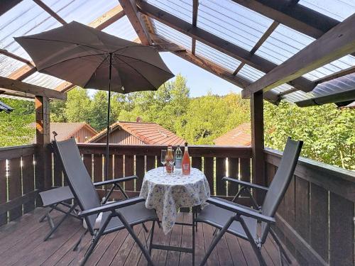 a table and chairs on a deck with an umbrella at Apartment Petra by Interhome in Grafenwiesen