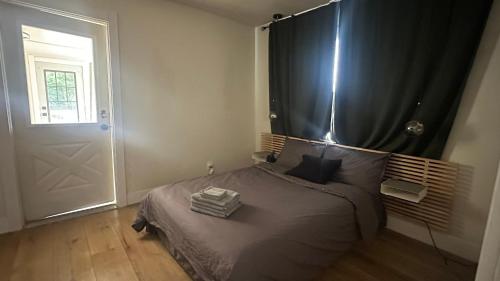 a bedroom with a bed with a black curtain and a door at Comfortable Private Room Shared Bathroom in Vinita Park