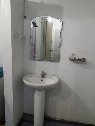 a bathroom with a sink and a mirror on the wall at The Home in Weligama