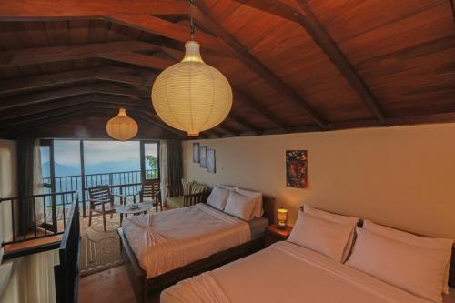 a hotel room with two beds and a balcony at O'Neill's Cottage in Dikkapitiya