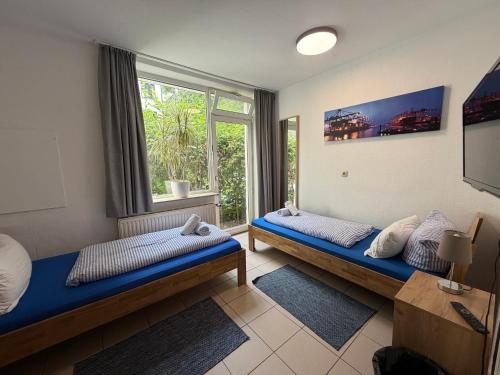 a room with two beds and a window at Basement Rotherbaum in Hamburg