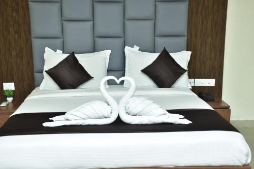 two white swans forming a heart on a bed at Hotel safal exotica in Puri