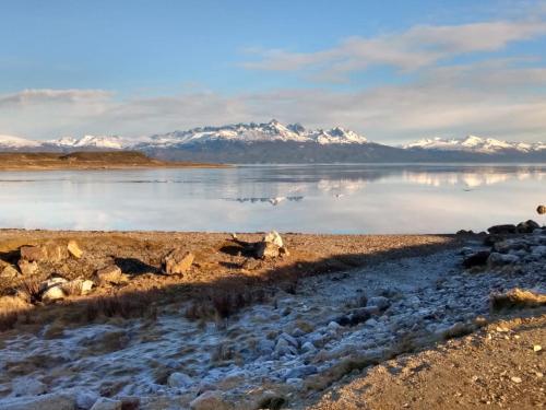 a body of water with snow covered mountains in the background at Las Margaritas in Ushuaia