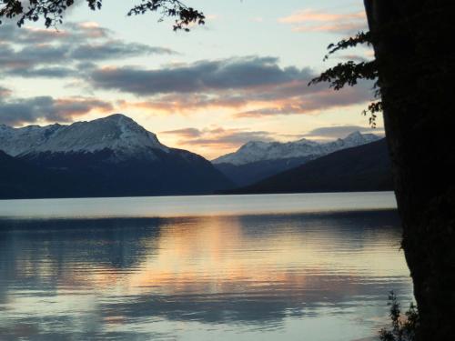 a sunset over a lake with mountains in the background at Las Margaritas in Ushuaia