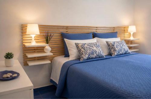 a bedroom with a blue bed with pillows and two lamps at Rifugio Caretta in Montecorice