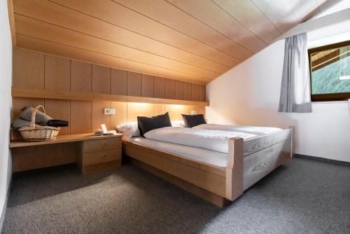 a bedroom with a large bed and a desk at Residence Grünwald in Valles