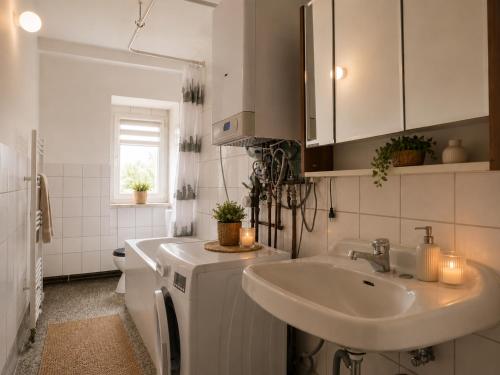 a white bathroom with a sink and a toilet at Apartments am Heimbach EG rechts in Kassel