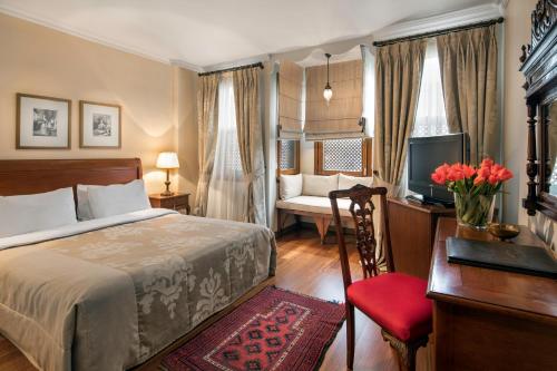 a bedroom with a bed and a desk and a television at Hotel Sari Konak in Istanbul