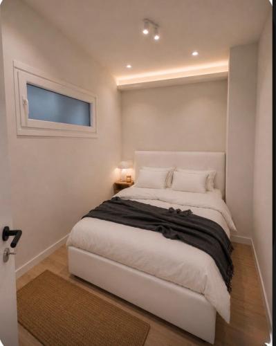 a bedroom with a large white bed with a window at Spiti mou - 2bd House in Mastihari