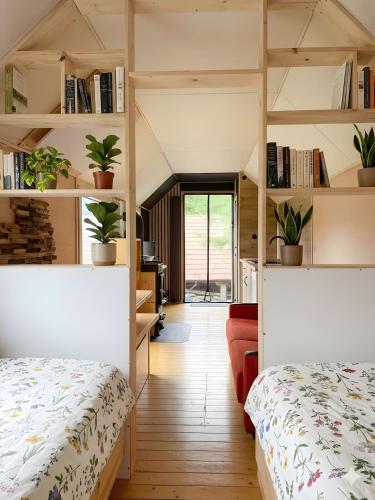 a room with two beds and shelves with plants at Tinyhaus in Dornburg