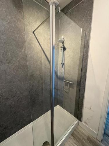 a shower with a glass door in a bathroom at The M Rooms at 158 in Shotts Station