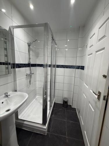 a white bathroom with a shower and a sink at Rutland Point in Uppingham