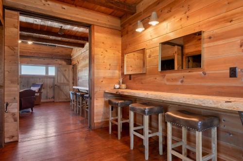 a bar in a cabin with wooden walls at Yellowstone Valley Lodge, an Ascend Collection Hotel in Pray