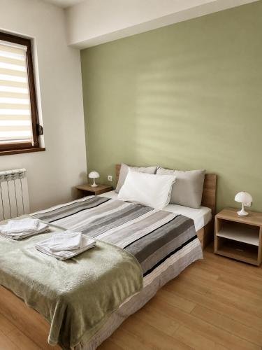 a bedroom with a large bed and a window at Urban Taft Stay Skopje-Modern Vodno View Suite with Private Parking in Taftalidze in Skopje