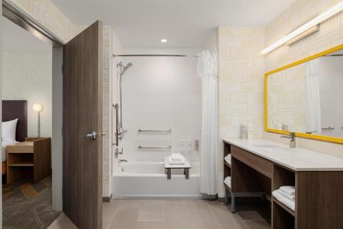 a bathroom with a tub and a sink and a shower at Home2 Suites By Hilton Springfield in Springfield