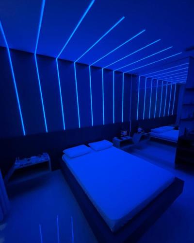 a room with two beds in a room with blue lights at Luxus Motel Caldas do Jorro in Tucano