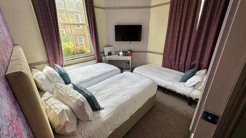 a hotel room with two beds and a window at Hammersmith Belle in London