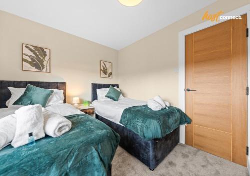two beds sitting next to each other in a bedroom at 2Br House I Sleeps 4 I Cumbernauld in Cumbernauld