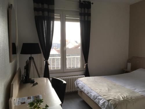 a hotel room with a bed and a window at Hotel La Terrasse in Fort-Mahon-Plage