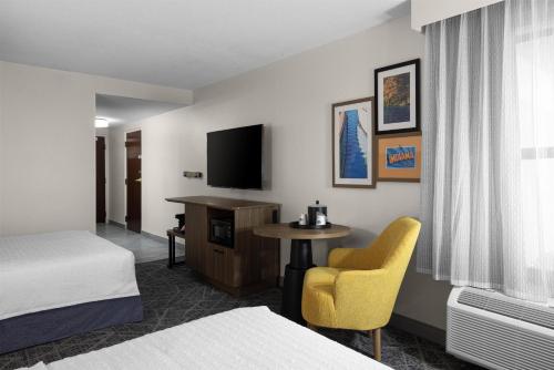 a hotel room with a bed and a table and a tv at Hampton Inn Terre Haute in Terre Haute