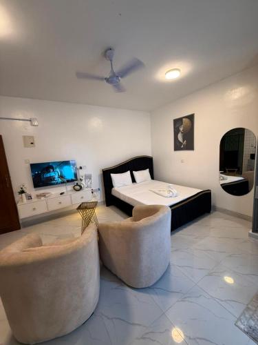 a bedroom with a bed and two couches in a room at Coastal comfort studio apartment in Mombasa