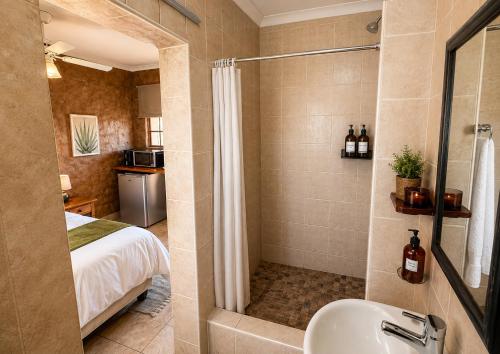 a bathroom with a shower and a bed and a sink at Linglela Lodge in Estcourt