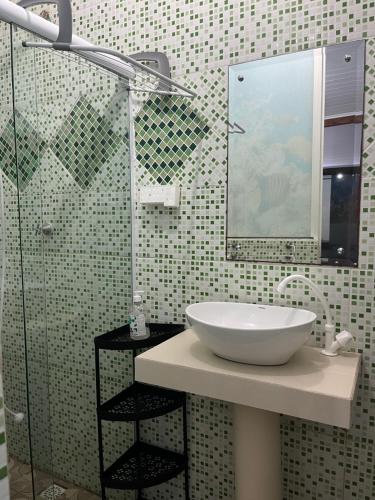 a bathroom with a sink and a glass shower at Hospedaria Gaúcha in Penha