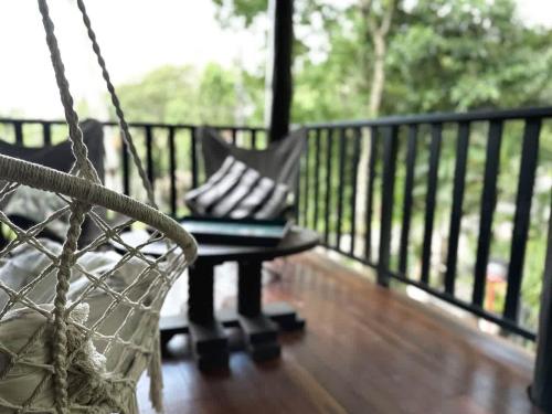 a porch with a hammock and a bench on a deck at The Treehouse - Rainforest Home - Pool in Smithfield