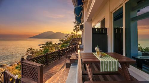 a balcony with a table and a view of the ocean at Namhae Opera House Pension in Namhae